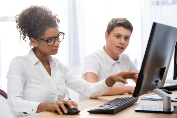 istock young teenager students pointing on screen of computer 901185254