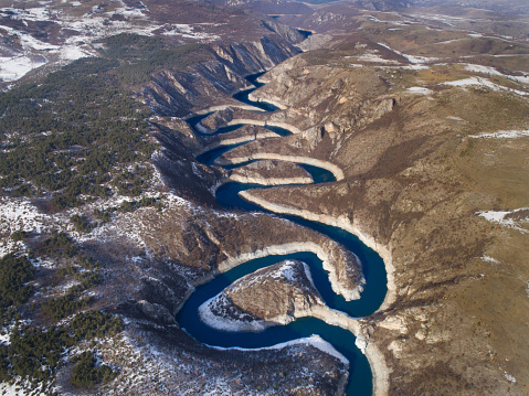 Aerial image of Uvac river forming meanders in mountain canyon in winter time in Serbia