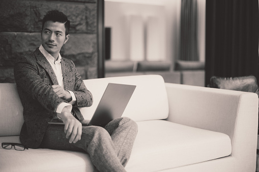 Businessman sitting on the sofa and using laptop