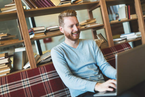 istock Handsome student working on laptop in bar 901190942