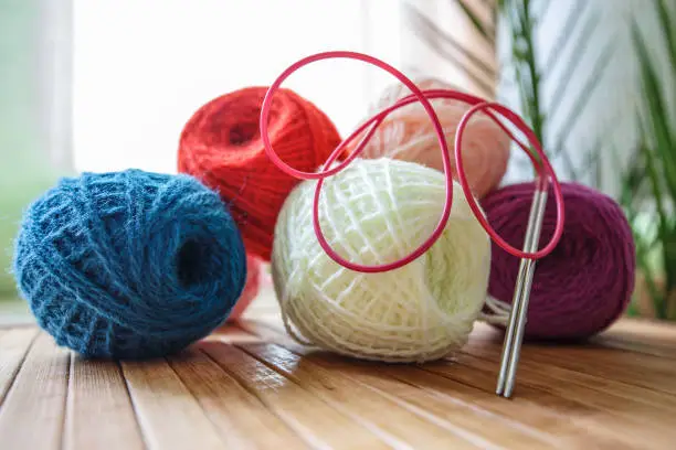 Knitting wool and knitting needles on a photo of home creativity. Knitting threads in tangles are an excellent texture and rich colors.