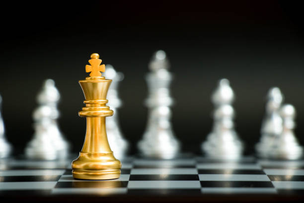Gold king in chess game face with the another silver team on black background (Concept for company strategy, business victory or decision) Gold king in chess game face with the another silver team on black background (Concept for company strategy, business victory or decision) king chess piece stock pictures, royalty-free photos & images
