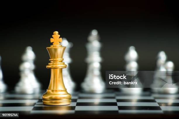 Gold King In Chess Game Face With The Another Silver Team On Black Background Stock Photo - Download Image Now