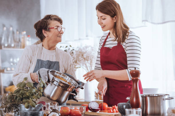 grand-mère et petite-fille de cuisine soupe - making soup photos et images de collection