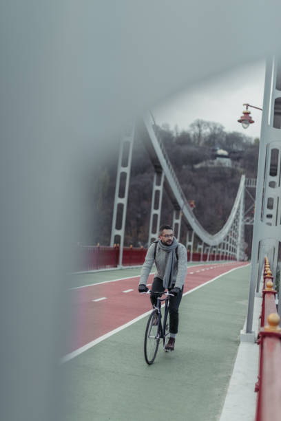 istock handsome adult man riding bicycle on pedestrian bridge 901199594