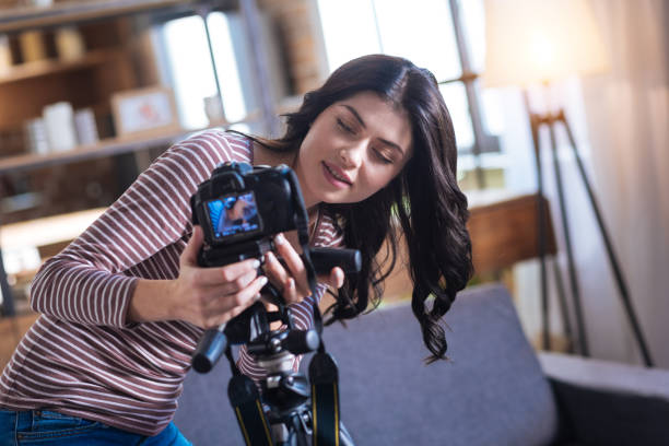 istock Positive pretty woman putting a camera on the tripod 901206852