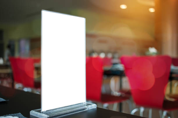 istock Mock up white Label for blank menu frame in Bar restaurant cafe., Stand for booklets with  sheets paper tent card on table cafeteria, blurred background insert for text of customer. Space for texting. 901209208