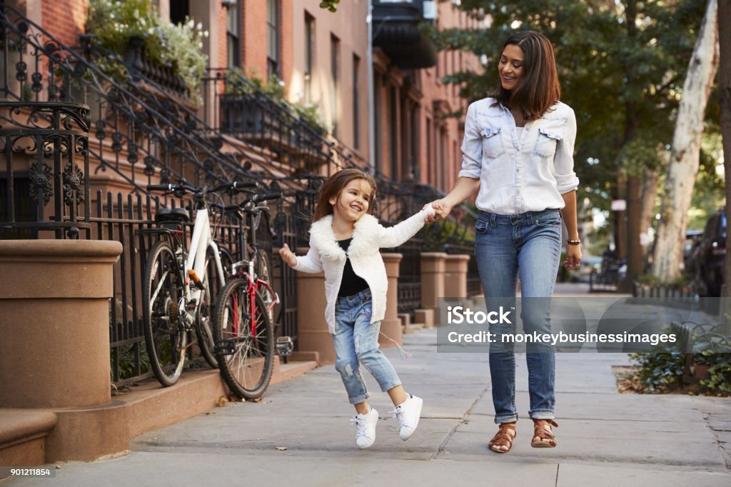 Mother and daughter walking down the street Mother Stock Photo