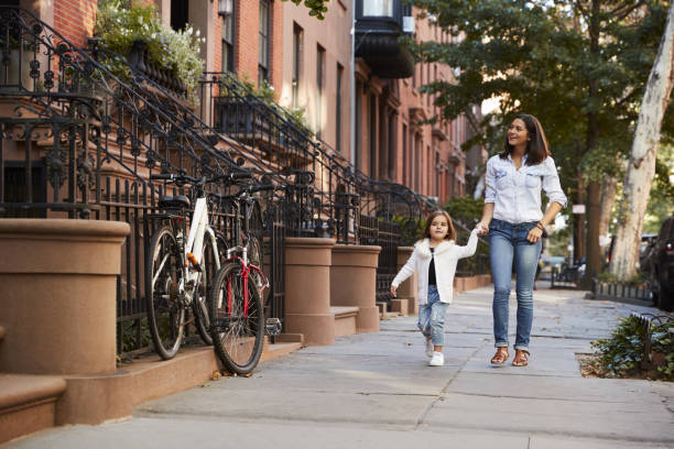 istock Mother and daughter walking down the street 901211892