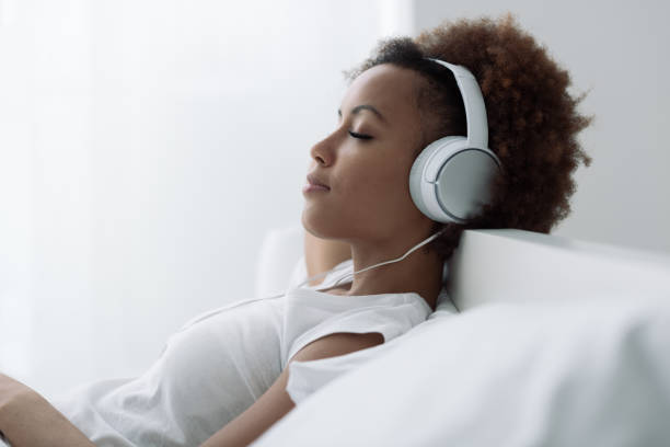 woman relaxing and listening to music - ouvir musica imagens e fotografias de stock