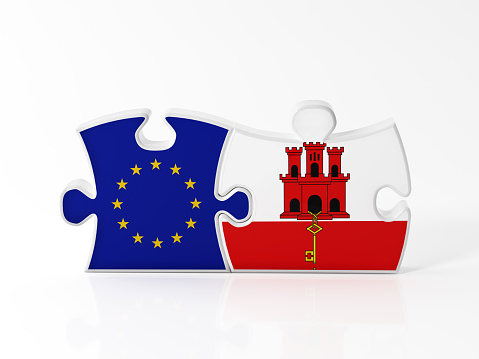 Jigsaw puzzle pieces textured with European Union and Gibraltar flags on white. Horizontal composition with copy space. Clipping path is included.