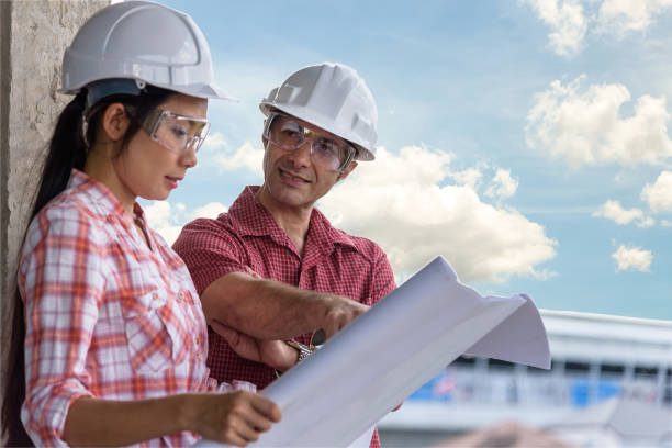 istock foreign Investor talking salesperson about the construction project with blurred engineers consulting in behind 901212230