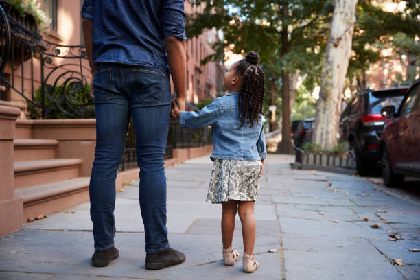 istock Father and daughter taking a walk down the street, back view 901212454