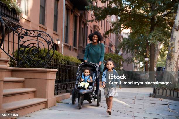 Madre E Due Figlie Che Camminano Per Strada - Fotografie stock e altre immagini di Passeggino - Passeggino, Famiglia, Camminare