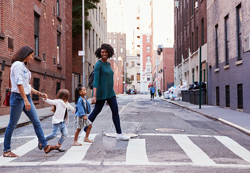 Dos amigos de la madre con dos hijas, cruzando la carretera photo