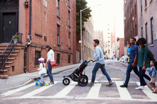 dos familias con hijas cruce camino - familia de cruzar la calle fotografías e imágenes de stock