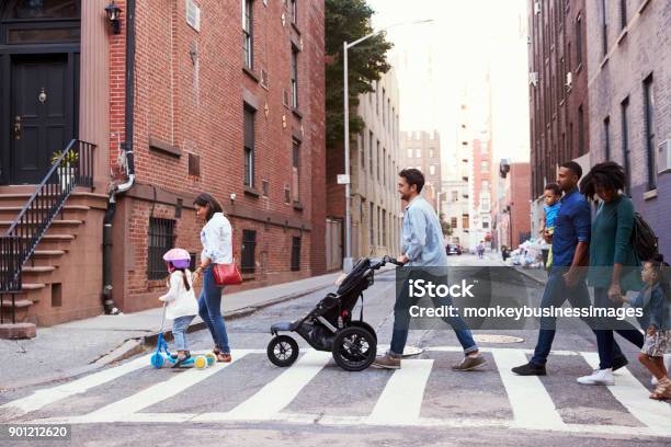 Two Families With Daughters Crossing Road Stock Photo - Download Image Now - City, Walking, Family