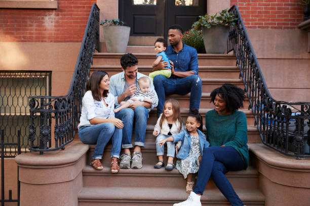 istock Two families with kids sitting on front stoops 901212642