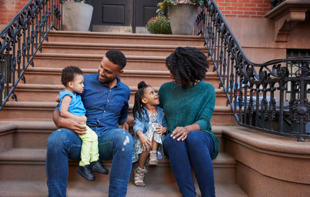istock Young family with kids sitting on front stoops 901212684