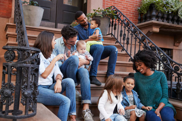 istock Two families with kids sitting on front stoops 901212690