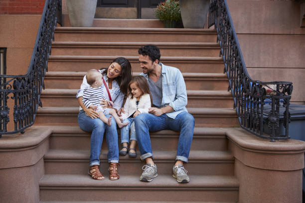 istock Young family with kids sitting on front stoops 901212718