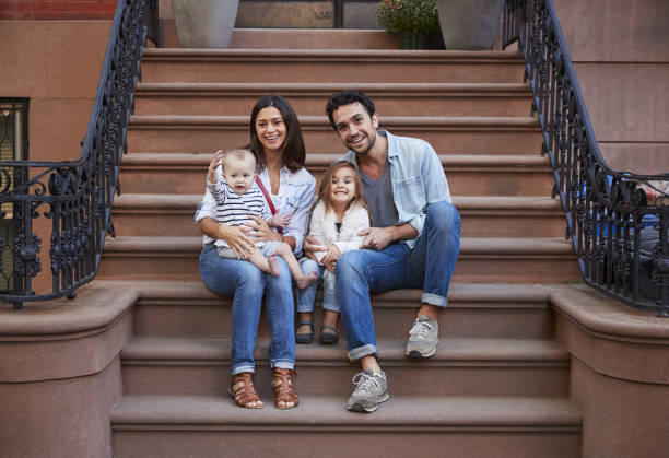istock Young family with kids sitting on front stoops 901212720