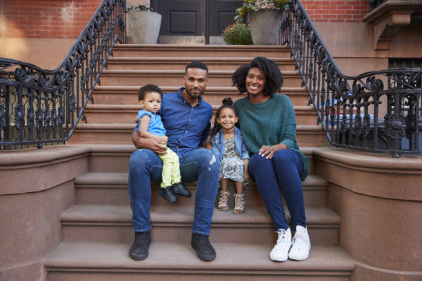istock Young family with kids sitting on front stoops 901212740