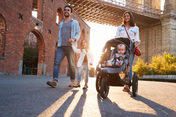 istock Young family with two daughters walk on a street 901212834
