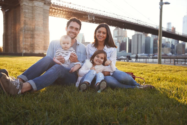 istock Young family with two daughters sitting on lawn, close up 901214882