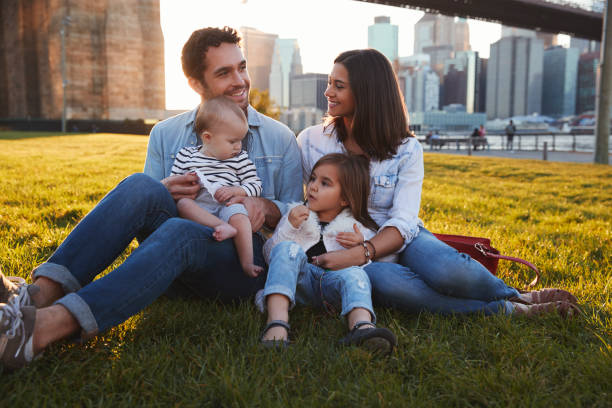 young family with two daughters sitting on lawn, close up - family white family with two children cheerful imagens e fotografias de stock