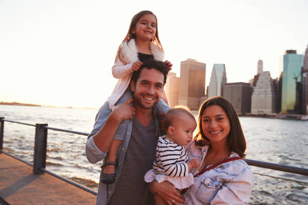 istock Young family with daughters standing on quayside, close up 901214938