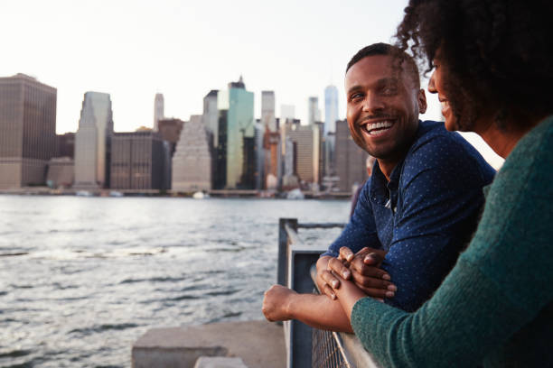 istock Young black couple standing on quayside, side view 901215010