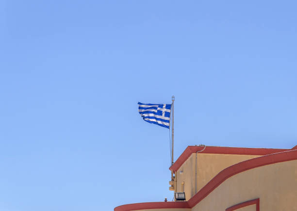 istock Greek flag waving on building with clean blue sky on summer day 901215330