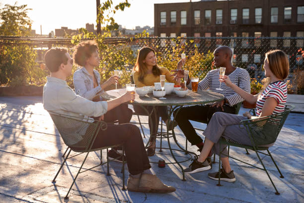 istock Friends talking on a New York rooftop raise glasses 901218604