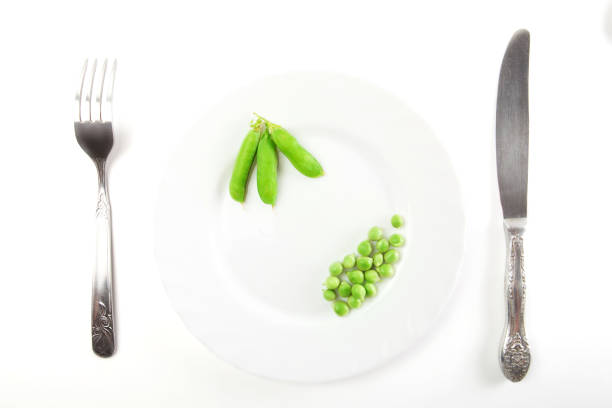 istock Peas with pods on a plate with knife and fork isolated on white background 901219058