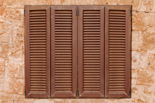 Brown wooden window on yellow castle old stone pattern texture wall close
