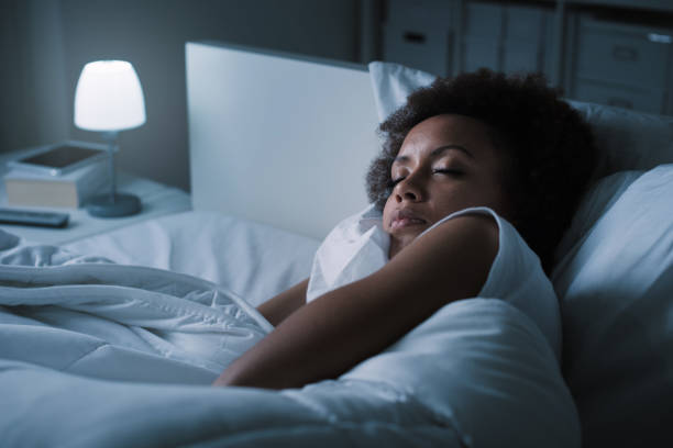 donna che dorme nel suo letto - adult sleeping women one person foto e immagini stock