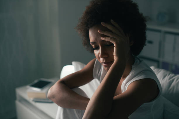 Sad woman suffering from insomnia Sad depressed woman suffering from insomnia, she is sitting in bed and touching her forehead, sleep disorder and stress concept insomnia photos stock pictures, royalty-free photos & images