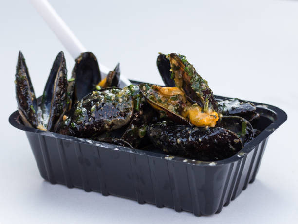 Belgian steamed mussels, moules-frites, in the plastic box Belgian steamed mussels, moules-frites, in the plastic box on the white table moules frites stock pictures, royalty-free photos & images