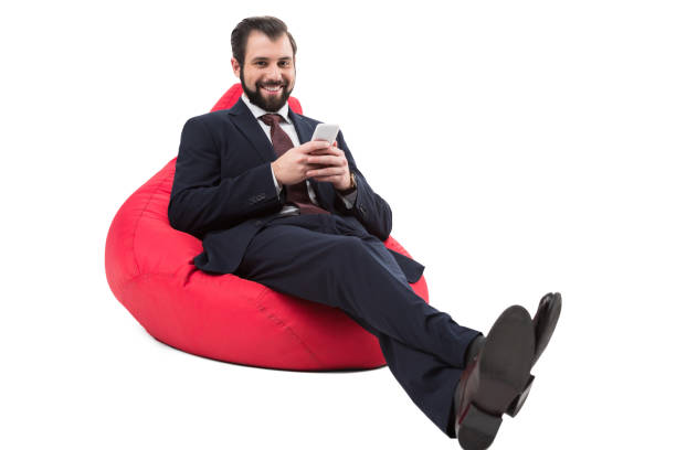 istock businessman with smartphone on bean bag chair 901224046