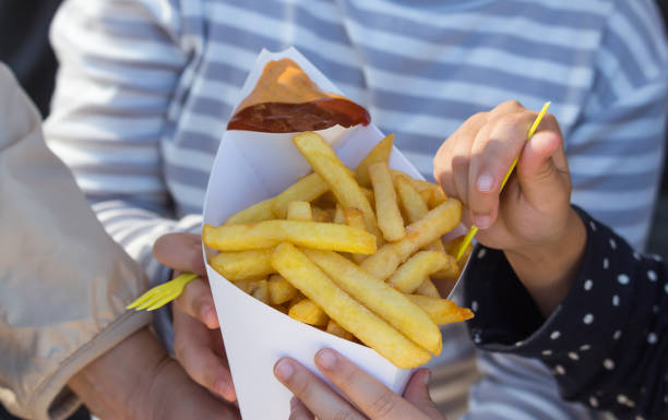 batatas fritas com molho nas mãos de mulher e criança - sauces sweet sauce cooking traditional culture - fotografias e filmes do acervo