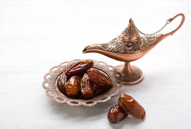 istock Bronze plate with dates and  aladdin lamp on a white wooden background. 901228808