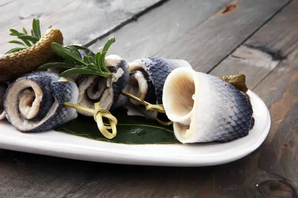 Traditional rollmops, stuffed pickled herring fillets,on a dish