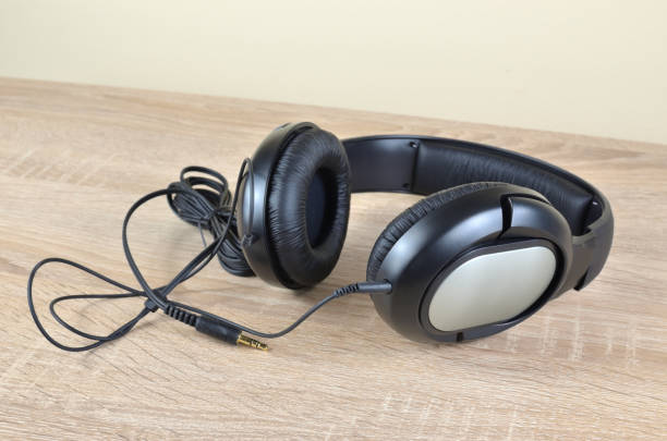 istock Black headphones on a desk 901228860