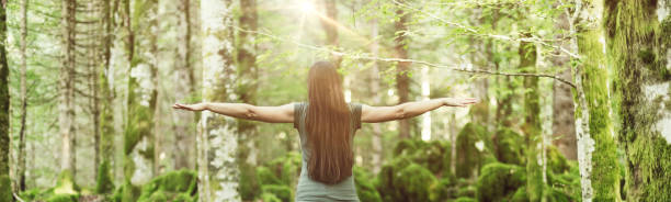 Woman spreading arms in the forest