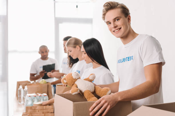 istock volunteer holding teddy bear and box 901235014