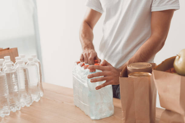 istock volunteer opening pack of water bottles 901235240
