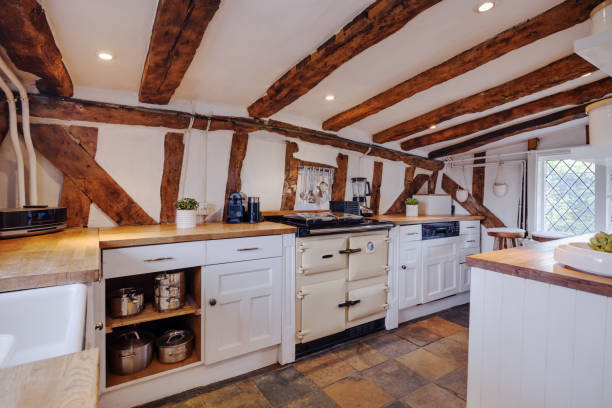 Modern kitchen with white cabinets, wooden shelves stocked with cookware and plants, a gas stovetop, and a clean white subway tile backsplash.