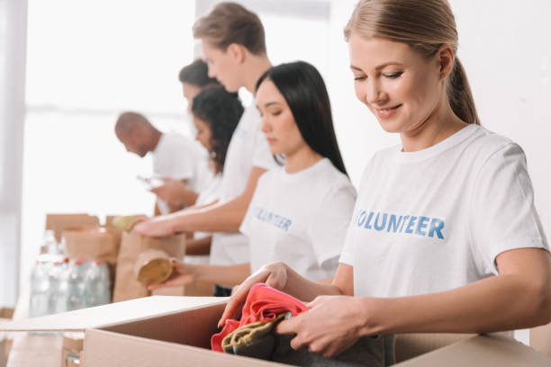 istock volunteer putting clothes into box 901235522