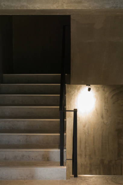 istock Dark staircase way up or down interior with light bulb 901235694